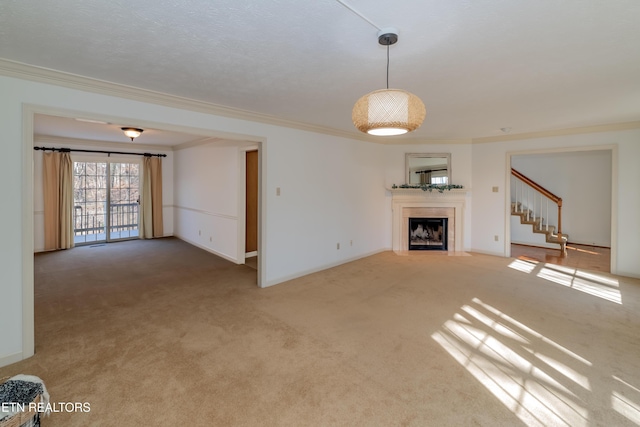 unfurnished living room featuring ornamental molding and carpet floors