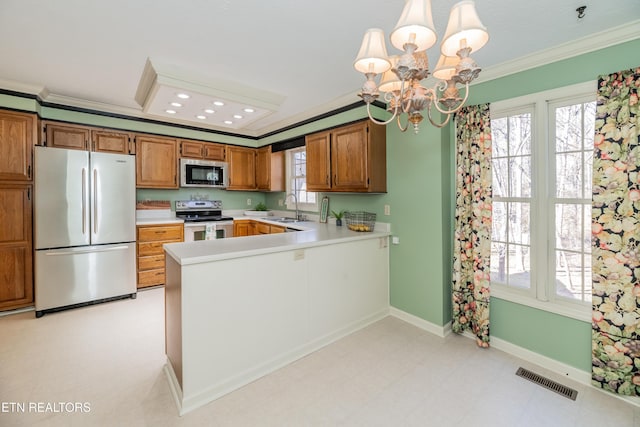 kitchen with hanging light fixtures, a notable chandelier, kitchen peninsula, stainless steel appliances, and crown molding