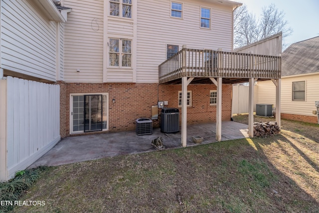 back of property featuring cooling unit, a wooden deck, a yard, and a patio area