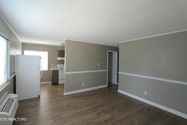 empty room featuring ornamental molding, dark wood-type flooring, a wall mounted AC, and a textured ceiling