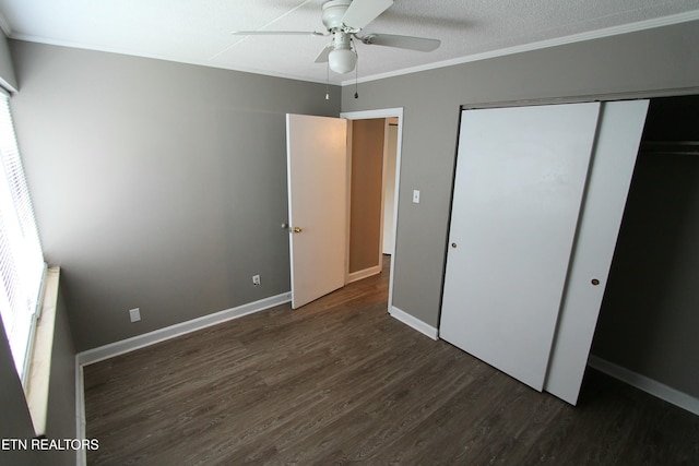 unfurnished bedroom featuring dark hardwood / wood-style floors, ornamental molding, ceiling fan, a textured ceiling, and a closet