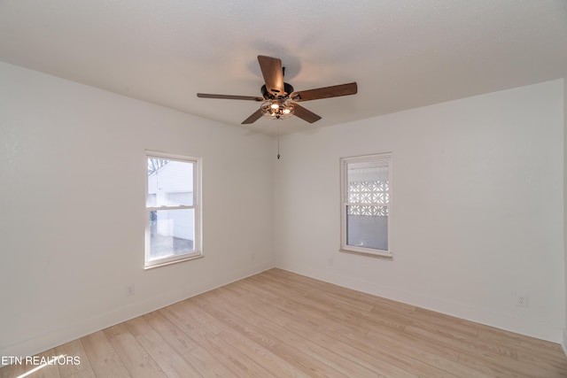 spare room with ceiling fan, a textured ceiling, and light wood-type flooring