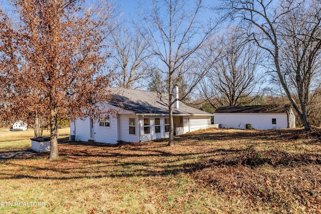 rear view of house featuring a yard