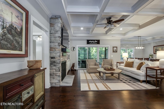 living room featuring coffered ceiling, a stone fireplace, dark hardwood / wood-style flooring, ceiling fan, and beam ceiling