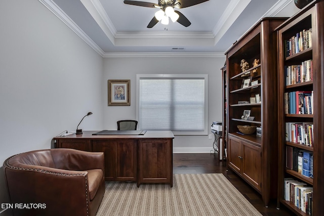 office with a tray ceiling, ornamental molding, dark hardwood / wood-style floors, and ceiling fan