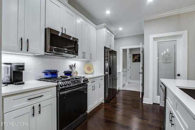 kitchen featuring white cabinetry, stainless steel appliances, crown molding, and backsplash