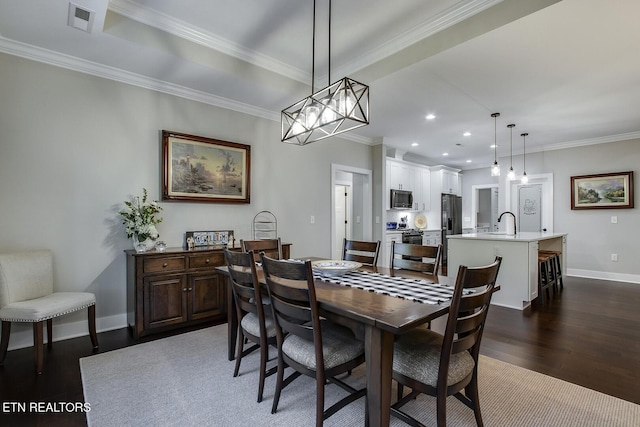 dining room featuring dark hardwood / wood-style flooring, sink, and ornamental molding