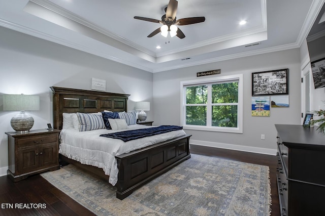 bedroom with a raised ceiling, crown molding, and dark hardwood / wood-style flooring