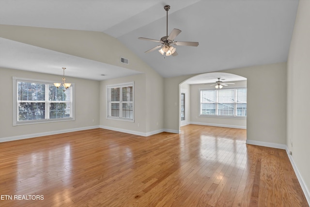 unfurnished living room featuring lofted ceiling, ceiling fan with notable chandelier, and light wood-type flooring