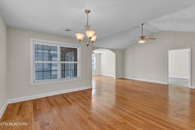 unfurnished room featuring ceiling fan with notable chandelier, light hardwood / wood-style flooring, and vaulted ceiling