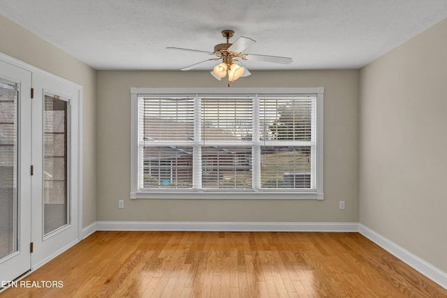 empty room featuring ceiling fan, light hardwood / wood-style flooring, and a wealth of natural light