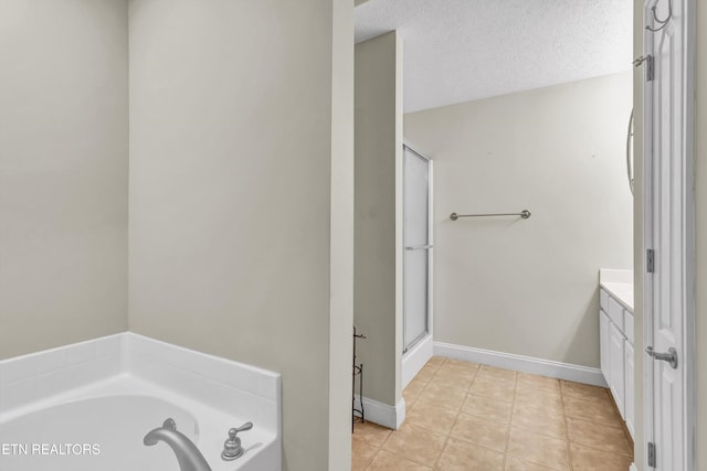 bathroom featuring independent shower and bath, vanity, tile patterned floors, and a textured ceiling