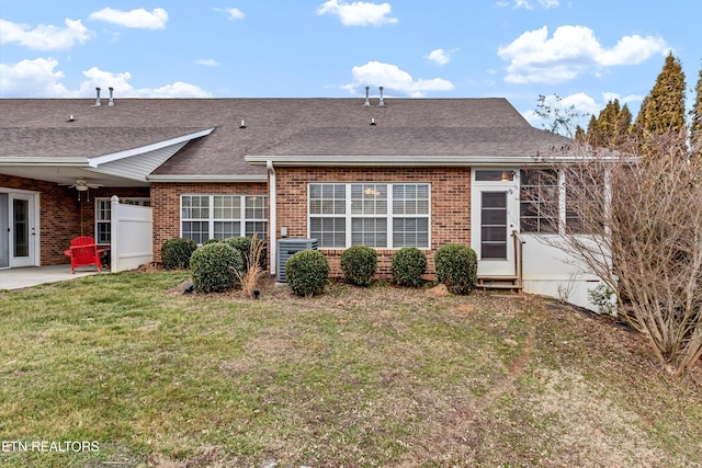 back of house with ceiling fan and a yard