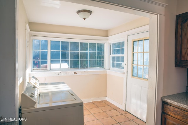 clothes washing area featuring light tile patterned flooring and washer and clothes dryer