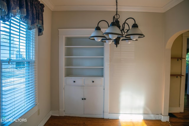 unfurnished dining area with an inviting chandelier, ornamental molding, and wood-type flooring