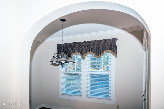 interior details with crown molding and a chandelier