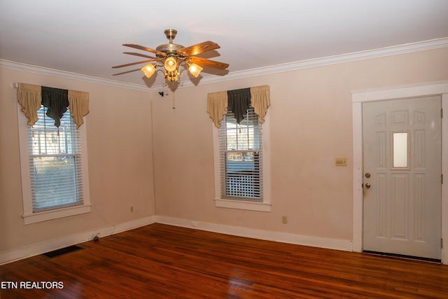 spare room featuring crown molding, plenty of natural light, and dark hardwood / wood-style floors