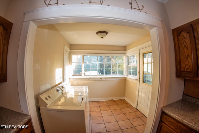 clothes washing area featuring light tile patterned flooring and washer and dryer