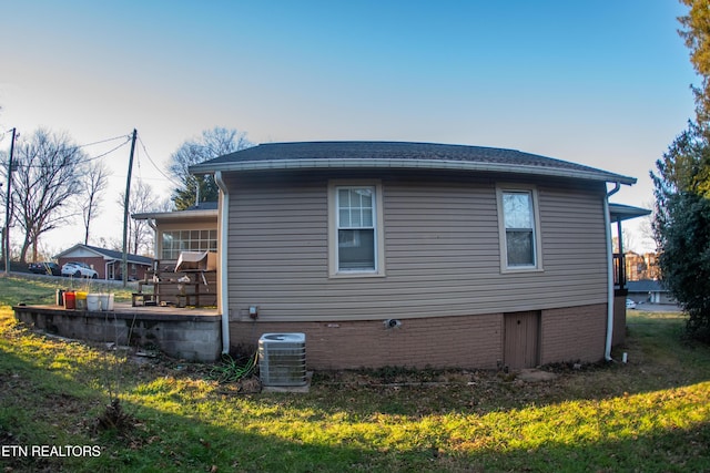 view of home's exterior featuring central AC unit and a lawn