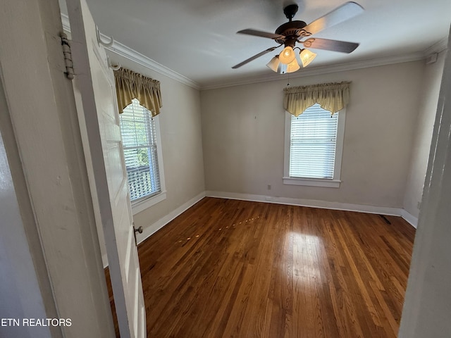 spare room with crown molding, ceiling fan, a healthy amount of sunlight, and dark wood-type flooring