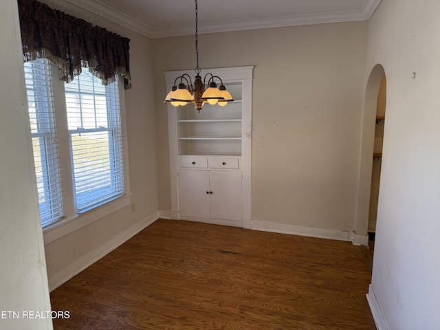 unfurnished dining area with crown molding, a chandelier, and dark hardwood / wood-style flooring