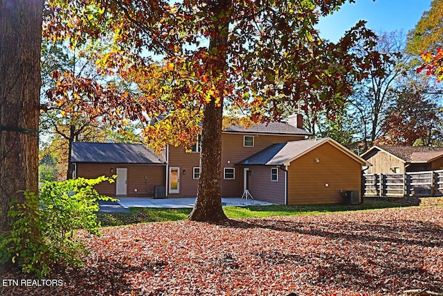 back of property featuring fence, a patio, a chimney, and central AC unit