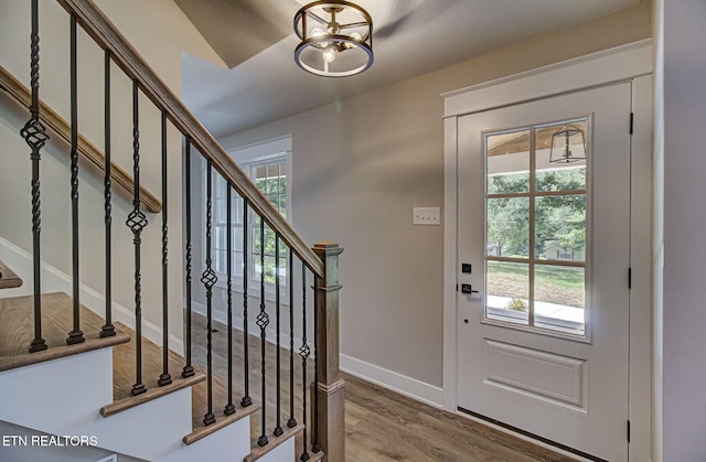 entrance foyer with hardwood / wood-style flooring, a healthy amount of sunlight, and a chandelier