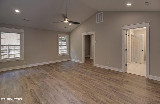 unfurnished bedroom featuring hardwood / wood-style flooring, connected bathroom, and vaulted ceiling