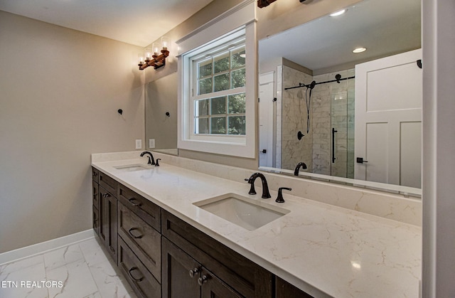 bathroom with marble finish floor, a sink, baseboards, and double vanity