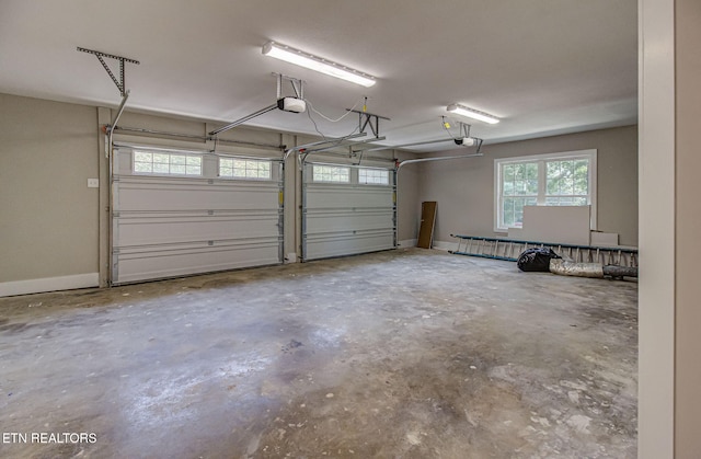 garage featuring a garage door opener and baseboards