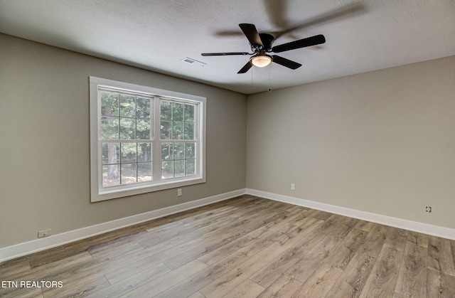 spare room featuring ceiling fan, light hardwood / wood-style floors, and a textured ceiling