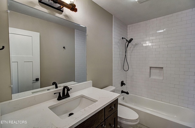 full bathroom with tiled shower / bath, vanity, and toilet