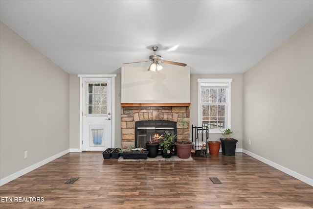 living room with dark wood-type flooring, ceiling fan, and a fireplace