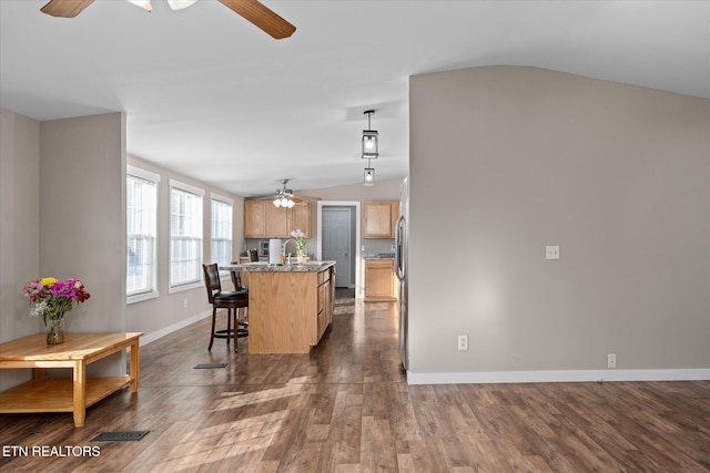 kitchen featuring lofted ceiling, sink, dark hardwood / wood-style flooring, a kitchen island with sink, and ceiling fan