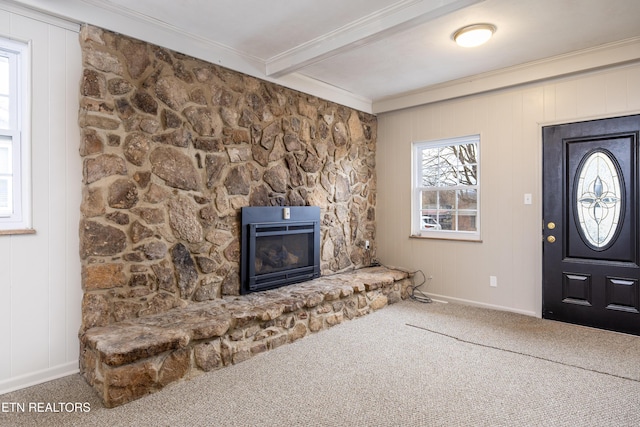 foyer featuring beamed ceiling, ornamental molding, carpet flooring, and a fireplace