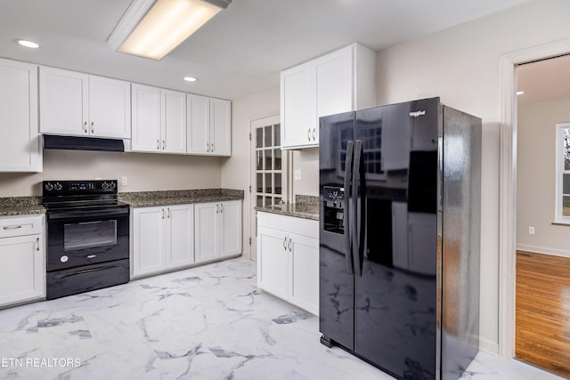 kitchen with white cabinetry, dark stone countertops, and black appliances