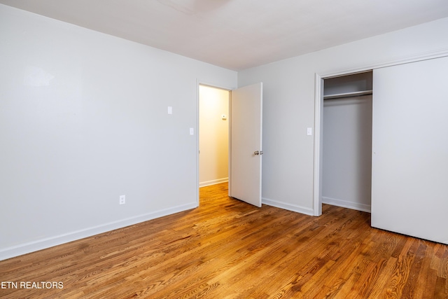 unfurnished bedroom with light hardwood / wood-style floors and a closet