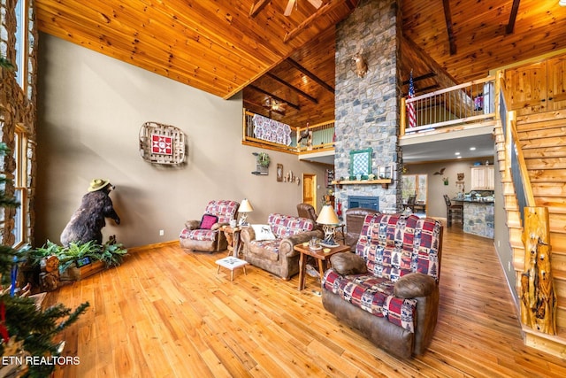 living room with high vaulted ceiling, a fireplace, hardwood / wood-style floors, and wooden ceiling