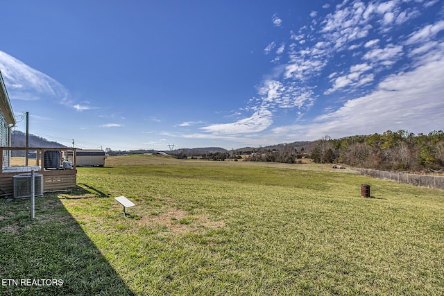 view of yard with cooling unit and a rural view