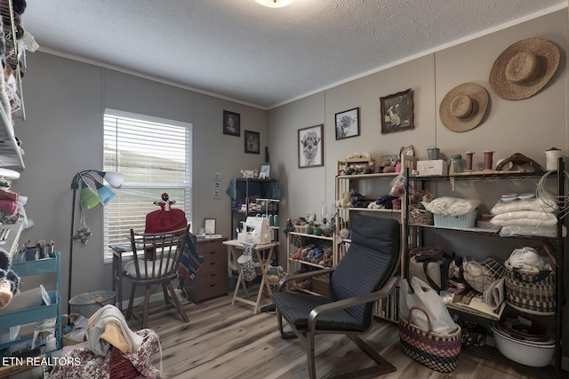 home office with hardwood / wood-style flooring, crown molding, and a textured ceiling