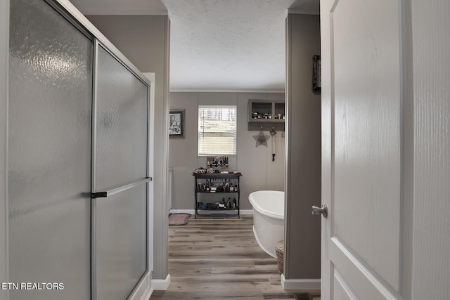 bathroom with independent shower and bath, hardwood / wood-style flooring, and a textured ceiling