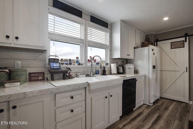 kitchen featuring sink, dishwasher, white refrigerator with ice dispenser, white cabinets, and a barn door