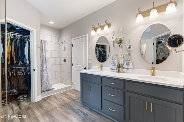 bathroom with vanity, wood-type flooring, and tiled shower