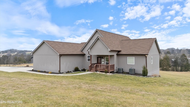 view of front of property with central AC unit, a deck, and a front yard