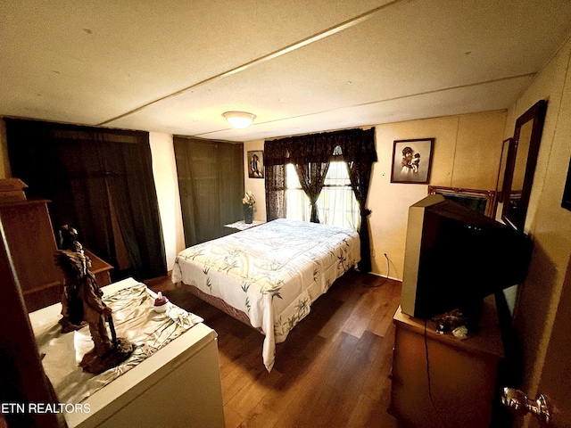 bedroom with dark wood-type flooring