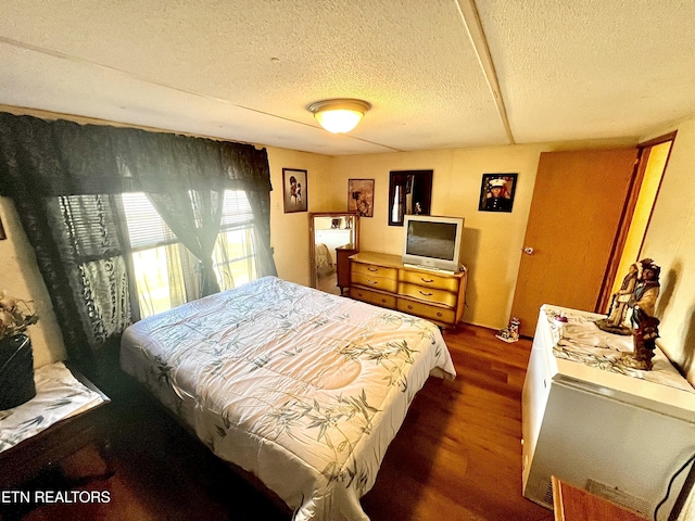 bedroom featuring dark hardwood / wood-style floors and a textured ceiling