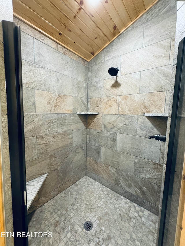 bathroom featuring lofted ceiling, tiled shower, and wooden ceiling