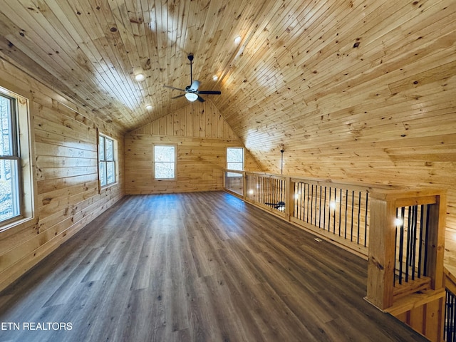 bonus room with dark hardwood / wood-style floors, wooden walls, lofted ceiling, ceiling fan, and wooden ceiling