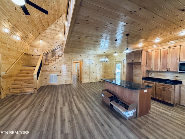 kitchen with pendant lighting, wood walls, a center island, dark wood-type flooring, and wooden ceiling