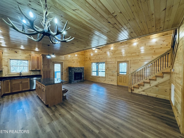 kitchen with dark hardwood / wood-style floors, stainless steel dishwasher, a fireplace, and wooden ceiling